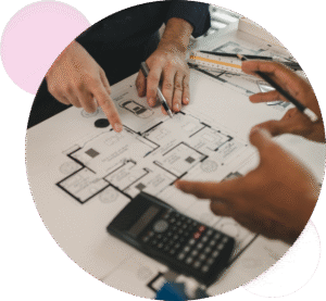 An Architect and a QS looking over a floor plan with a calculator on the drawing