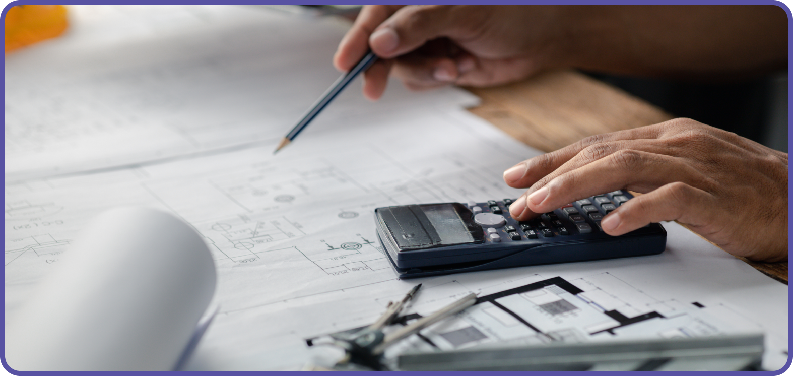 Man looking at building plans with pencil and calculator to hand