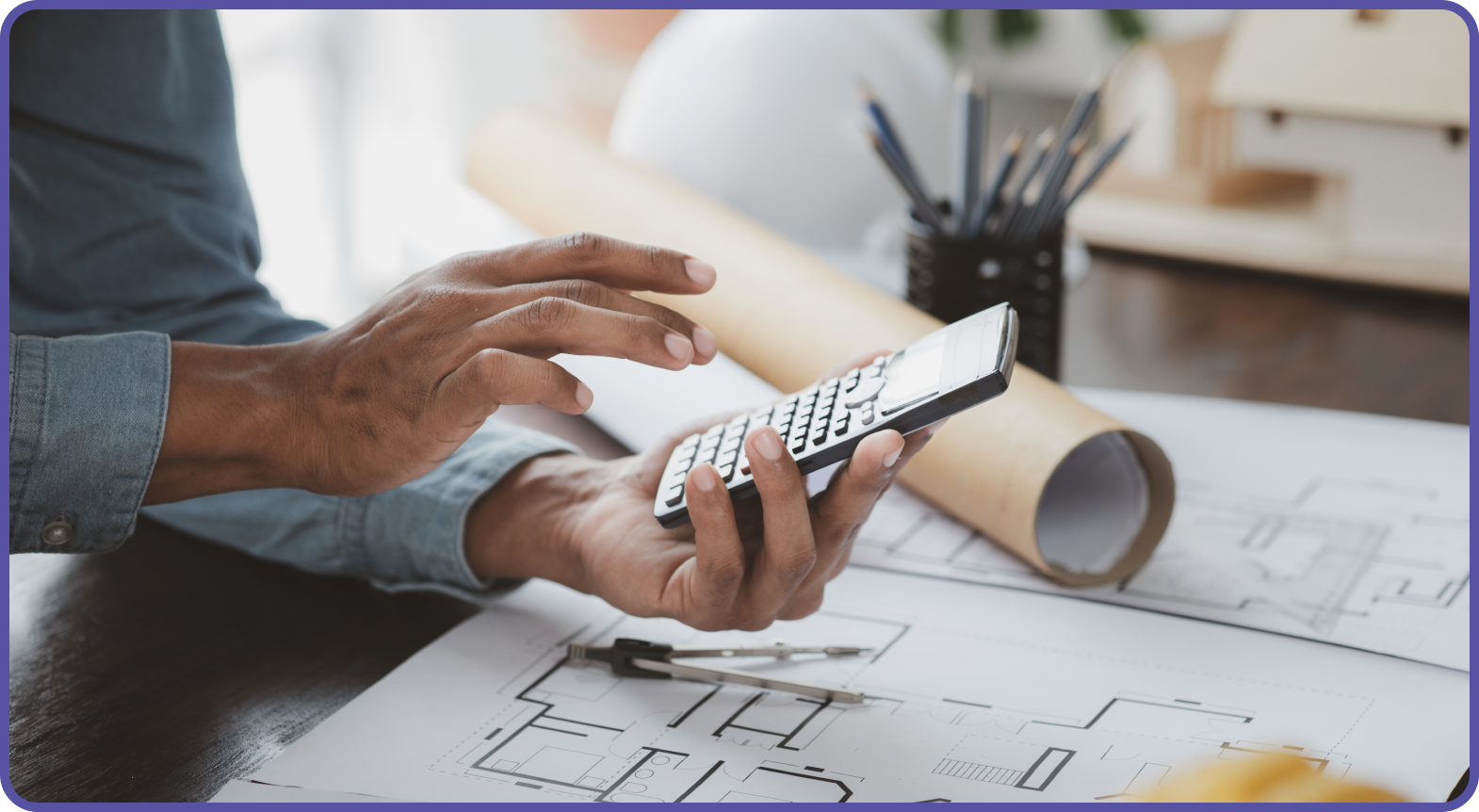 Quantity Surveyor working out the area of a building on a calculator overlooking drawings