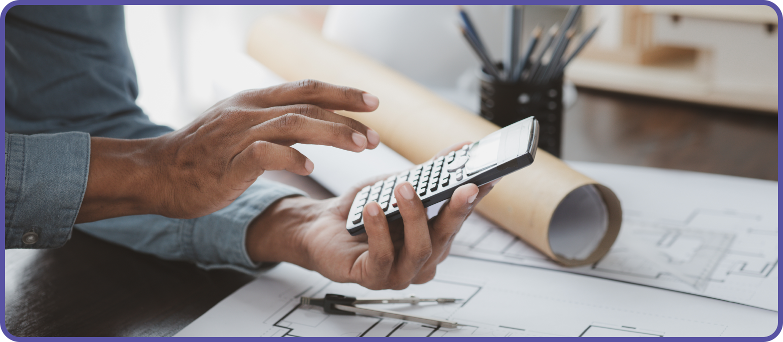 man with calculator with a roll of architectural drawings